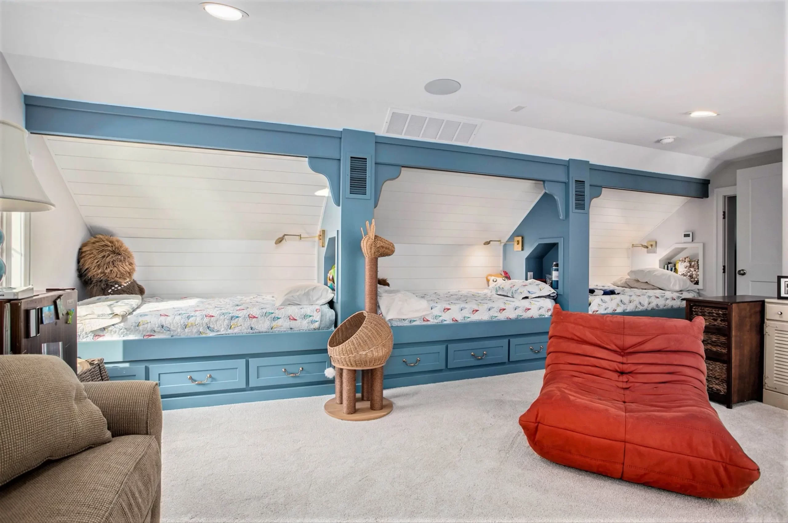 Custom built-in bunk beds with blue trim, white shiplap walls, and cozy children’s sleeping spaces