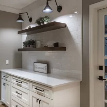 White Cabinets with White Counter and Tiled wall with Floating Shelves