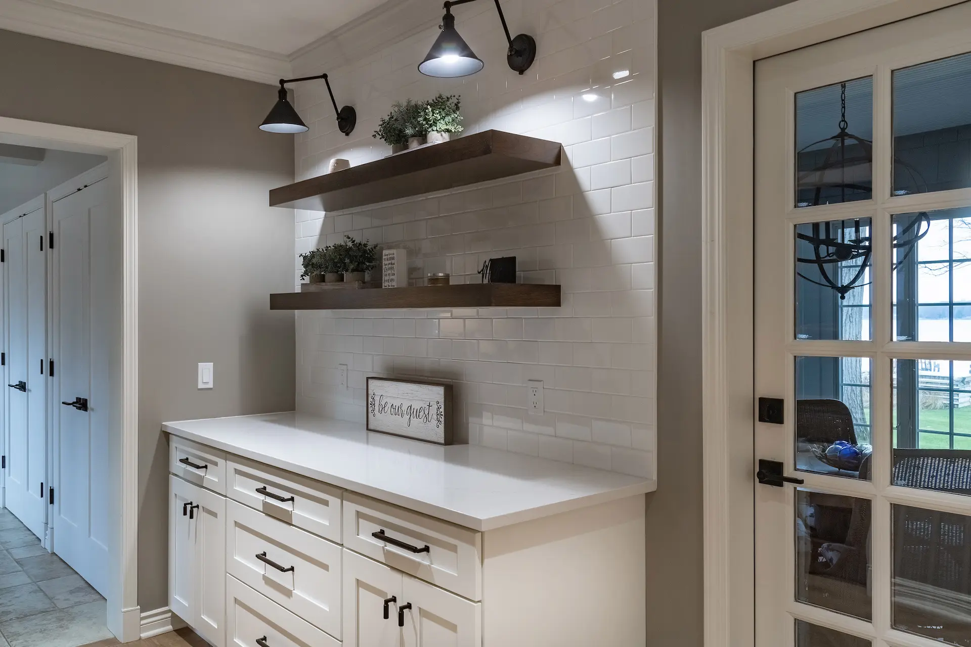 White Cabinets with White Counter and Tiled wall with Floating Shelves