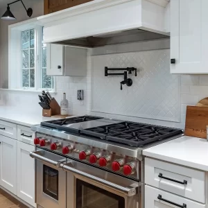 Wolf Range with red knobs and a black pot filler