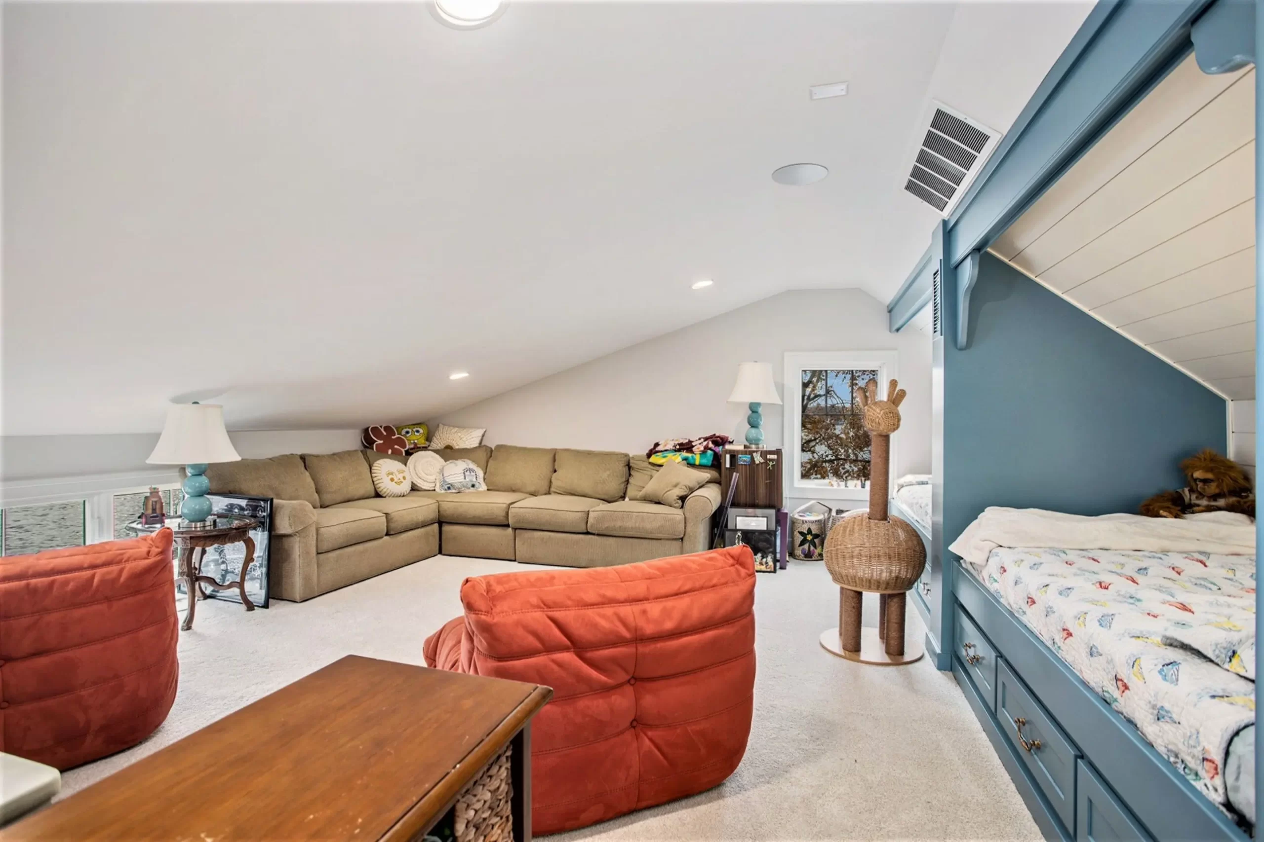 Spacious lakefront home loft with built-in bunk beds, sectional sofa, and family lounge area