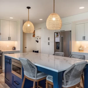 Kitchen with blue island, white countertops, woven pendant lights, stainless steel range, white cabinets, and tile backsplash