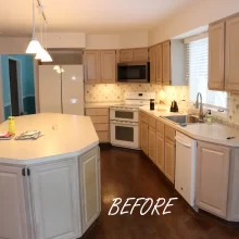 Kitchen with dark wood flooring and worn light brown cabinets and dated appliances