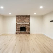Updated living room with new lvp wood flooring, white paint and floor to ceiling windows that line the left side of the image facing the backyard