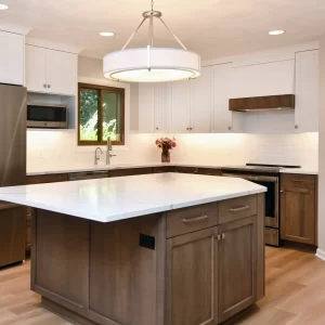 Custom kitchen with wood island, white upper cabinets, wood lower cabinets, quartz countertops, stainless steel appliances, and pendant light