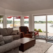 Lakefront living room with sliding glass doors opening to a deck and Austin Lake views