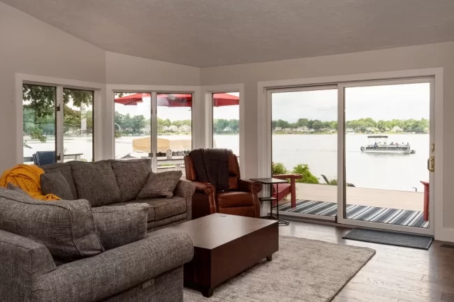Lakefront living room with sliding glass doors opening to a deck and Austin Lake views