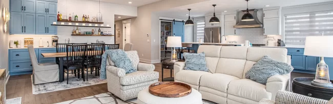 Open Concept Lakefront Living Room and Kitchen | Pennings & Sons Open concept living room, dining area, kitchen, and blue beverage bar in a lakefront home