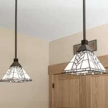 Close-up of stained glass pendant lights above natural wood cabinetry and trim