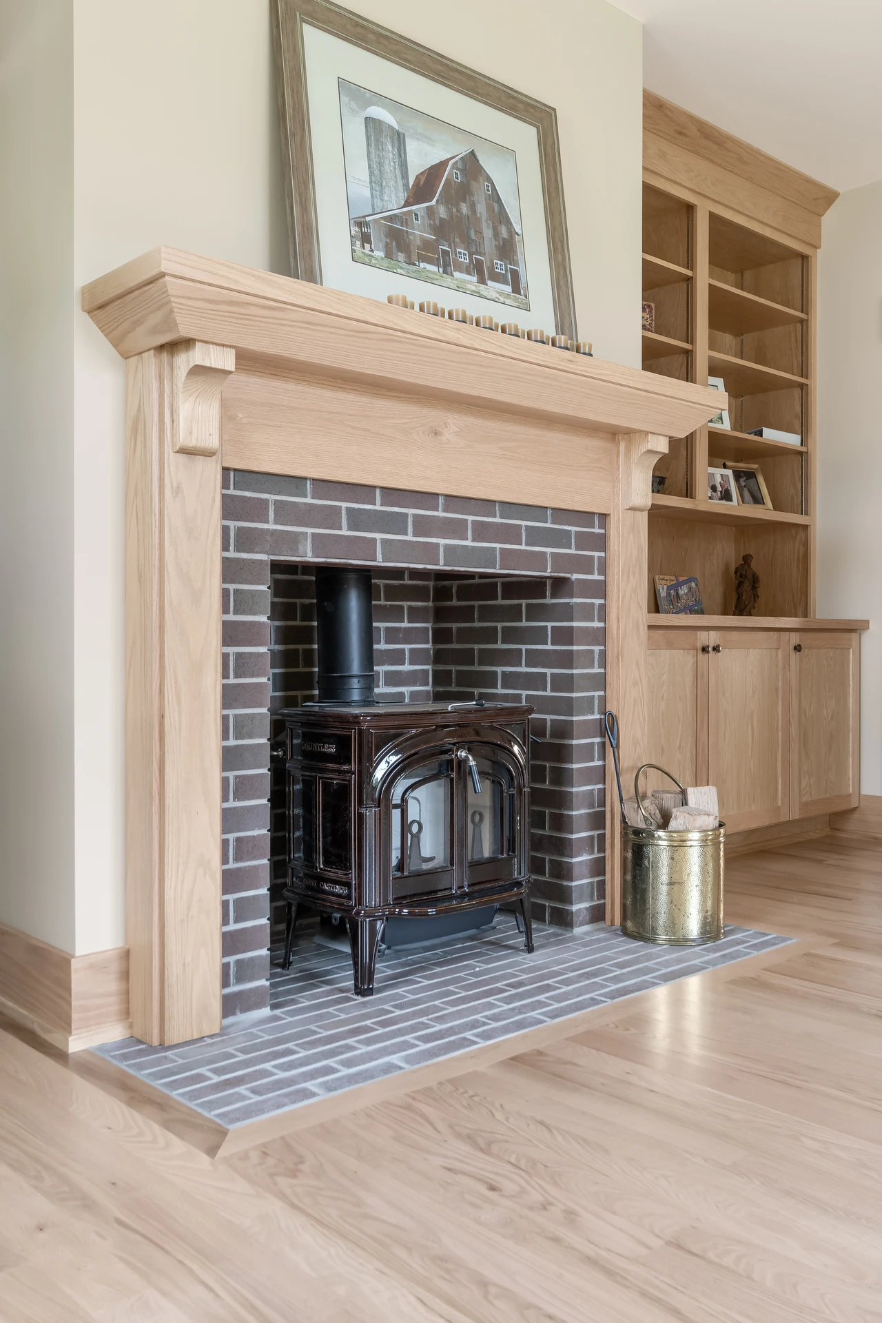 Custom wood mantel surrounding a brick stove fireplace with built-in cabinetry and shelving nearby