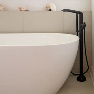 Glass shower with dark stone accents beside a freestanding tub in a modern primary bathroom