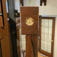 Wood Housing for Elevator Call Station Button leading toward a custom home elevator with glass panels and warm brown interior finishes