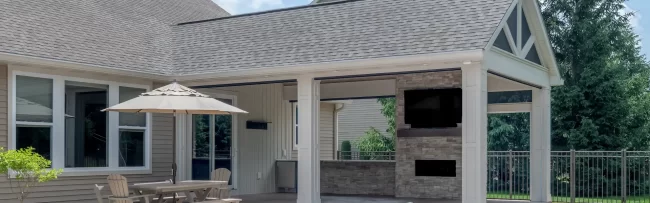 Expanded backyard patio with covered seating area, pool, and outdoor fireplace feature