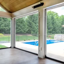 View from inside the covered patio through retractable screens toward the pool and backyard.