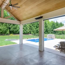 Covered patio with wide openings, retractable screens, and a view of the backyard pool