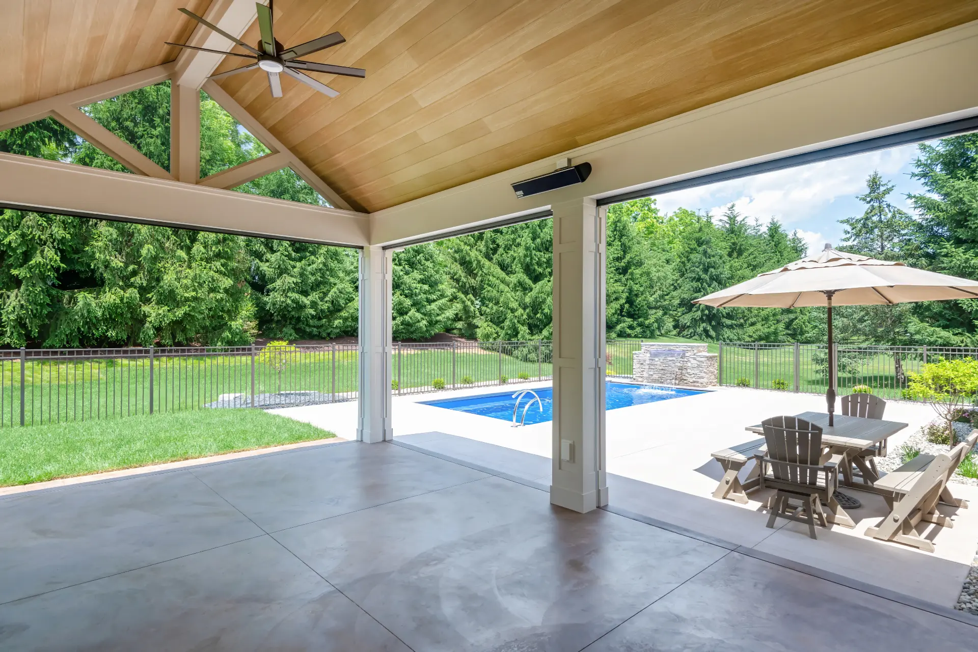 Covered patio with wide openings, retractable screens, and a view of the backyard pool