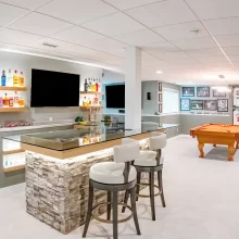 Finished basement rec room with a custom bar, pool table, sports memorabilia, and arcade games