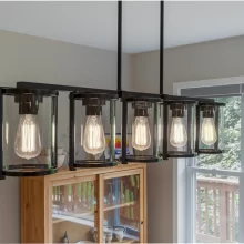 Close-up of a black-framed glass pendant light fixture above a dining area