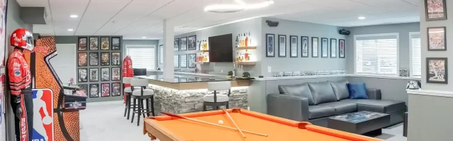 Finished Basement Game Room and Lounge | Pennings & Sons Finished basement game room with pool table, custom bar, lounge seating, and sports décor