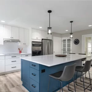 Blue kitchen island with bar seating, white perimeter cabinets, pendant lights, and stainless appliances